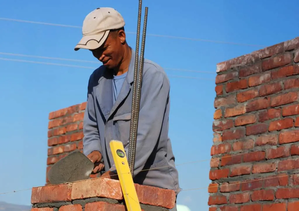 Albañil levantando un muro de ladrillo