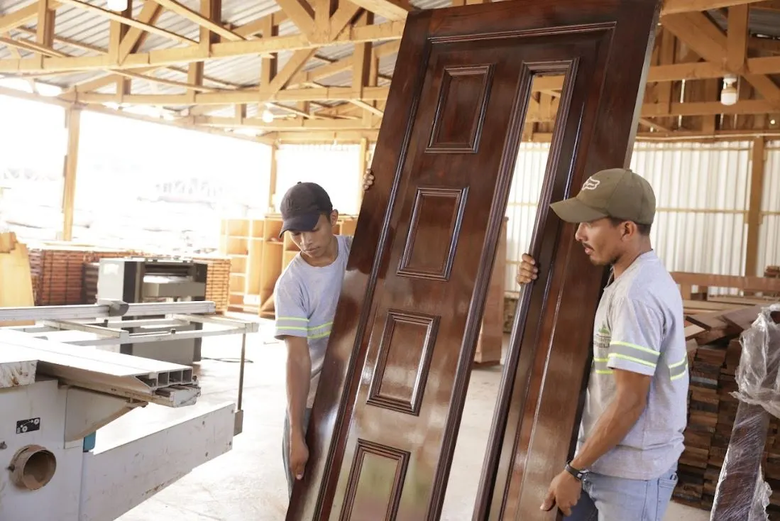 Carpinteros trasladando una puerta de madera